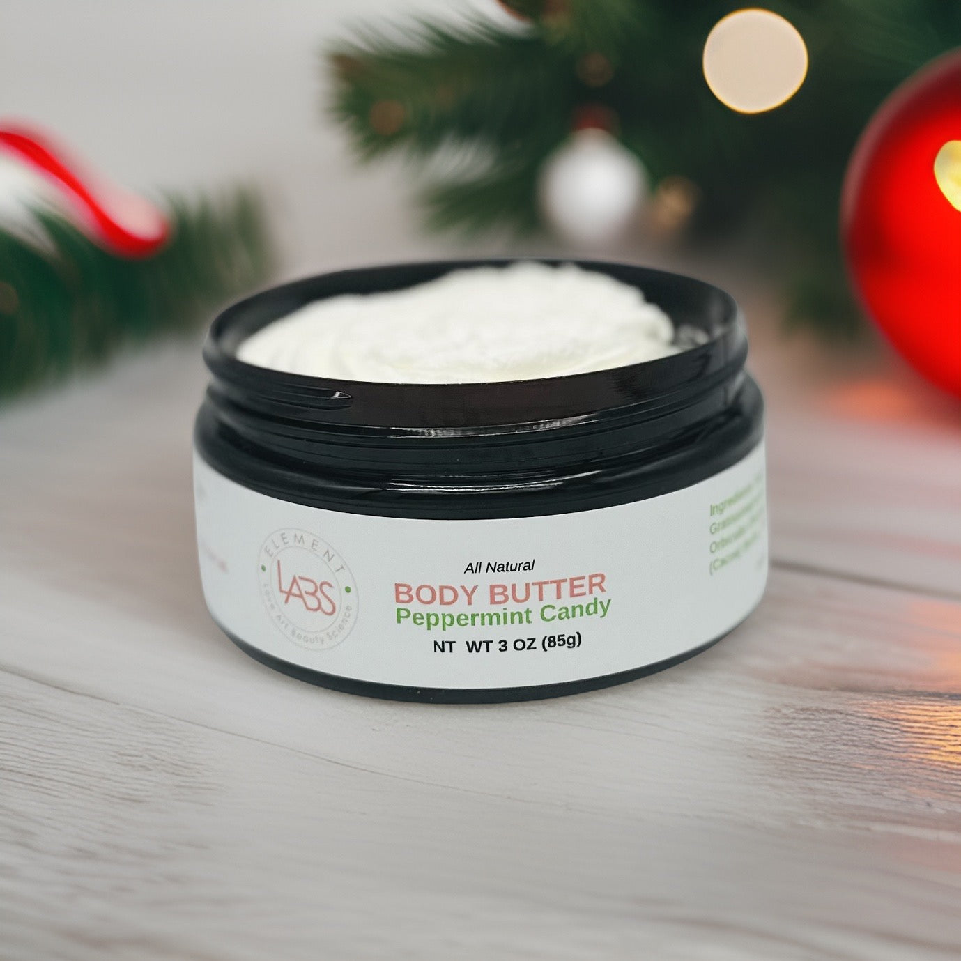 Light fluffy body butter in a dark color jar. Scented in peppermint Candy. Made with organic oils and butters. Scented in peppermint Candy. Hand made, natural skincare.